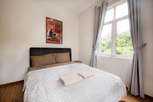 a bedroom with a bed with two towels on it at New Shamrock Beach Villas Seaview in Batu Ferringhi