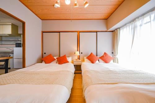 two beds in a room with a window at 弥富民泊 - Yatomi Minpaku - in Yatomi 