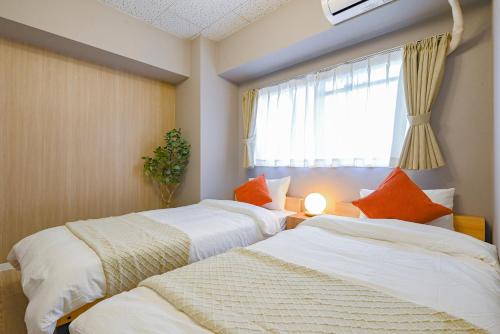 two beds in a room with a window at 弥富民泊 - Yatomi Minpaku - in Yatomi 