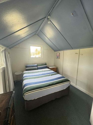 a bedroom with a bed in a small room at Lime Ridge Farm Cottage in Fairlie