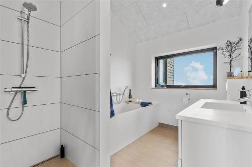 a white bathroom with a shower and a sink at 8912-Allingabro-Fyrrevej-6 in Allingåbro