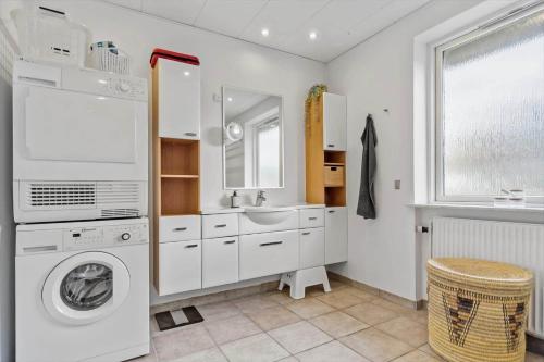 a white bathroom with a washing machine and a sink at 8592-Glesborg-Muslingevej-9 in Glesborg