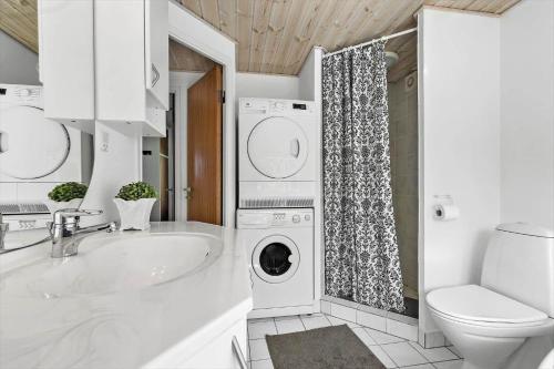 a bathroom with a washing machine and a sink at 8903-Allingabro-Fyrrevej-12 in Allingåbro