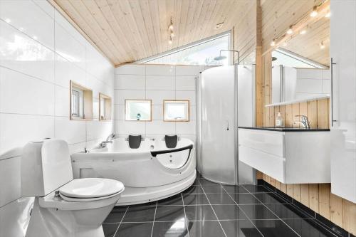 a bathroom with a tub and a toilet and a sink at 8995-Orsted-Alsikevej-9 in Ørsted