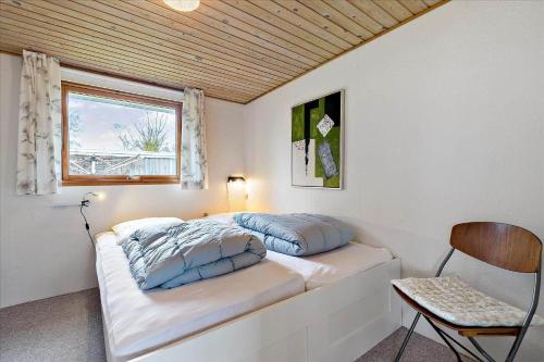 a bedroom with two beds and a window and a chair at 8503-Grenaa-Ellevej-29 in Grenå