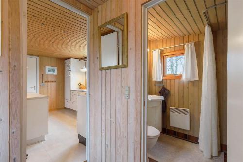 a bathroom with a toilet and a sink and a mirror at 8503-Grenaa-Ellevej-29 in Grenå