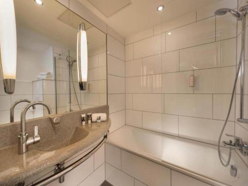 a bathroom with a sink and a shower at Sunday Saarbruecken Sued Standard Room in Saarbrücken