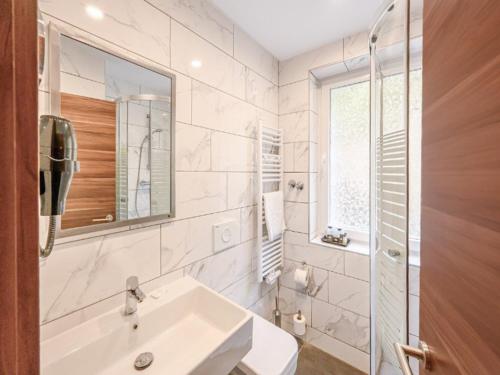 a white bathroom with a sink and a mirror at Sunday Schwarzbachtal Double Room Forest View in Erlbach