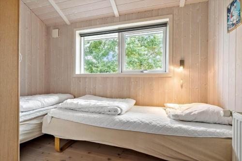 two beds in a room with a window at 8519-Grenaa-Nobilisvej-13 in Grenå