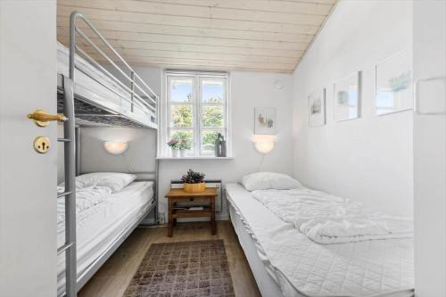 a bedroom with two beds and a window at 8908-Allingabro-Poppelvej-7 in Allingåbro