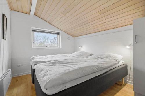 a bed in a room with a wooden ceiling at 8848-Glesborg-Floden-4 in Glesborg