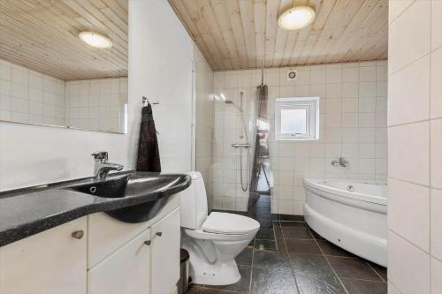 a bathroom with a sink and a tub and a toilet at 8848-Glesborg-Floden-4 in Glesborg