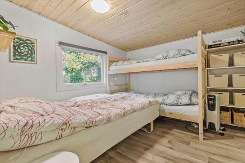 a bedroom with two bunk beds and a window at 8963-Orsted-Spovevej-6 in Ørsted