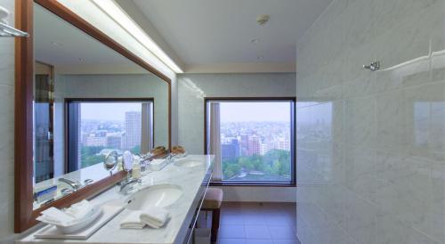 a bathroom with two sinks and a large mirror at Premier Hotel Nakajima Park Sapporo in Sapporo