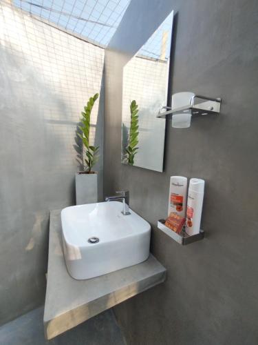 a bathroom with a white sink and a mirror at Villa Carlos Tangalle in Tangalle