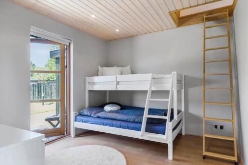 a bedroom with two bunk beds and a ladder at 8565-Grenaa-Kystvej-58 in Grenå