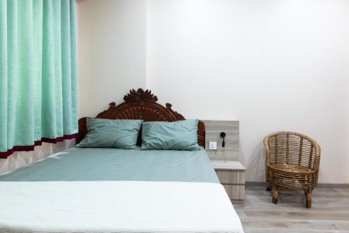 a bedroom with a bed and a wicker chair at Jhigu Casa Homestay in Kirtipur