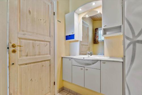 a bathroom with a sink and a mirror and a door at 8960-Orsted-Ternevej-15 in Ørsted