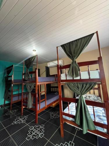 a room with three bunk beds in a boat at Hostel Caiçara in Santo Amaro