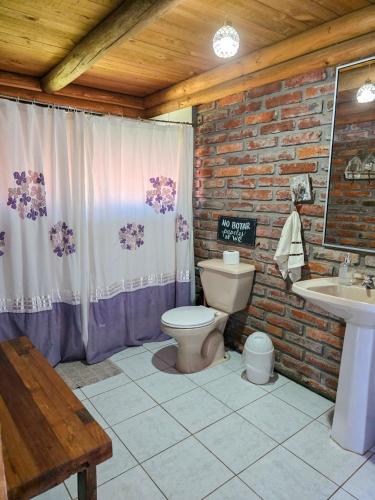 a bathroom with a toilet and a sink at Casa Amanecer Vichuquén in Vichuquén Lake
