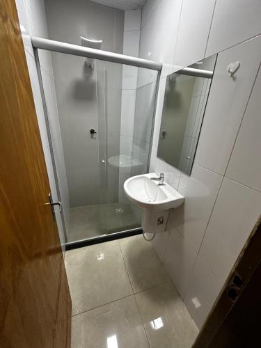 a bathroom with a sink and a shower with a mirror at Hostel Salazar in Campo Grande