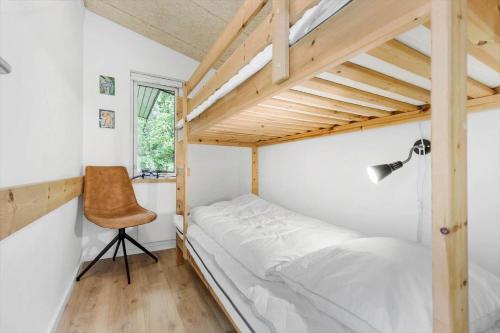 a small bedroom with a bed and a chair at 8017-Knebel-Manhojvej-1 in Knebel