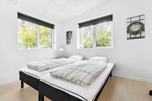 two beds in a white room with two windows at 84160-Ebeltoft-Baekholmen-5-A in Ebeltoft