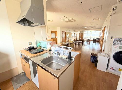 a kitchen with a sink and a dishwasher at ハイ沖縄金武店トイレお風呂共用 プレオープン中駐車場有 ペット同伴可能長期滞在可能2025年10月より車貸し出しサービス有希望であればお申し付けください in Kin