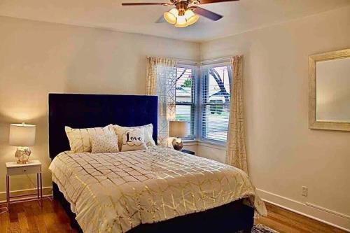 a bedroom with a bed with a ceiling fan and a window at Large Fenced Yard, Pool Table, Disney Central in Fullerton