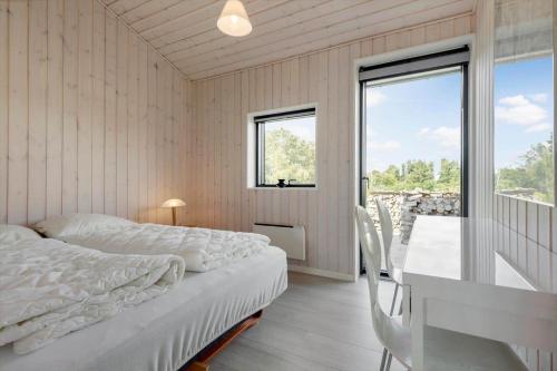 a bedroom with a bed and a desk and a window at 84213-Ebeltoft-Lokevej-8 in Ebeltoft