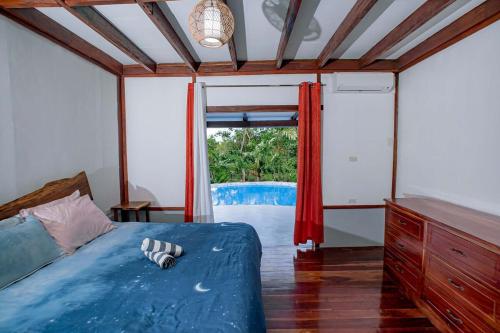 a bedroom with a bed and a view of a pool at Eco-Villa Camiguin in Mambajao