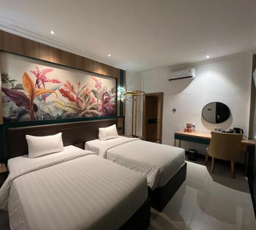 a hotel room with two beds and a desk at Bona Ventura Hotel & Skybar in Tanjung Pinang