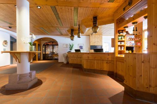 a large room with wooden ceilings and a counter at Hotel Laaxerhof in Laax
