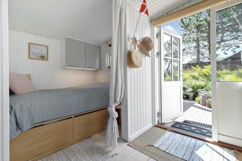 a bedroom with a bed and a sliding glass door at 8224-Knebel-Capellavej-7 in Knebel