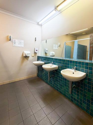 a bathroom with two sinks and a mirror at Global Backpackers Youth Hostel in Port Douglas