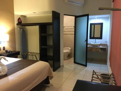 a hotel room with a bed and a bathroom at Hotel Centro Apatzingán in Apatzingán de la Constitución