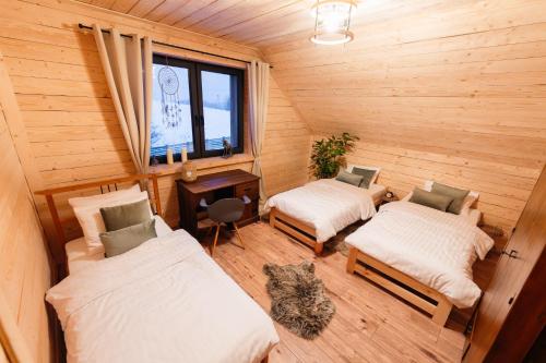 a small room with two beds and a cat in it at Eno Chata 240 m2 na wyłączność dla grup in Chojnik