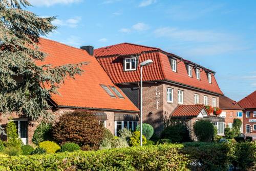 a house with an orange roof at Hotel Hilker in Bersenbrück