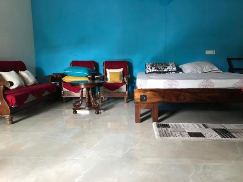 a room with three beds and a table and chairs at Lumbini in Varanasi