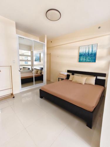 a bedroom with a large bed and a mirror at Pico hamilo coast condotel suite in Nasugbu