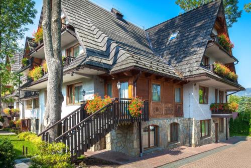 a large house with flower boxes on the side of it at Czarny Potok Wellness & Spa Zakopane Centrum in Zakopane