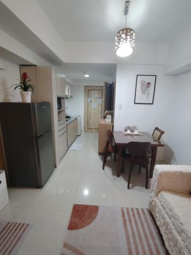a living room with a kitchen and a dining room table at Spacious Studio Davao in Davao City