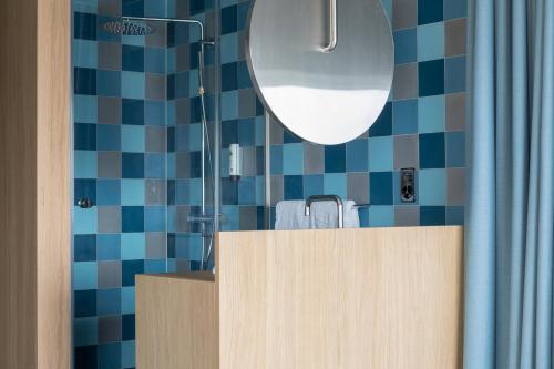 a bathroom with a vanity with a shower and a mirror at Placid Hotel Design & Lifestyle Zurich in Zürich