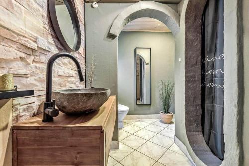 a bathroom with a sink and a stone wall at 84109-Ebeltoft-Birkevej-1 in Øksenmølle