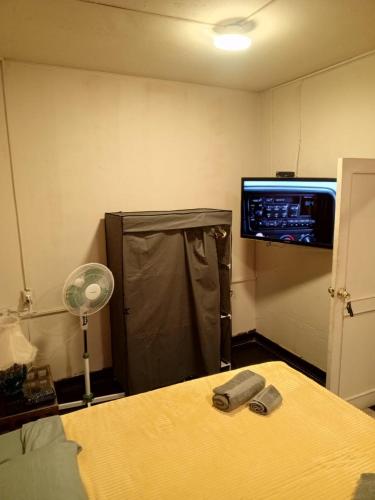 a room with a bed and a tv on the wall at Lima Centro Guest House Barrios in Lima