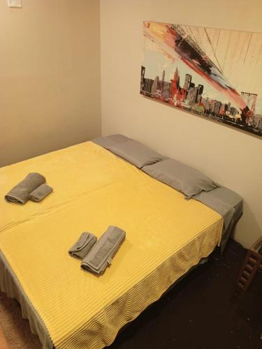 a yellow bed with two slippers on top of it at Lima Centro Guest House Barrios in Lima