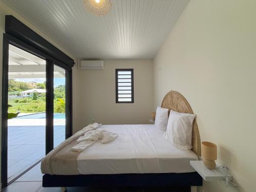 a bedroom with a bed and a large window at La Villa Serenity Pool in Le Lamentin