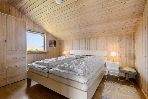 a bedroom with a large bed and a window at 84252-Ronde-Folfodvej-16 in Rønde