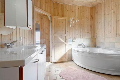 a white tub in a bathroom with wooden walls at 84266-Knebel-Toplaerkevej-1 in Knebel