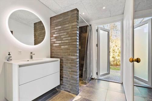 a bathroom with a sink and a brick wall at 8244-Knebel-Metholmvej-20 in Knebel